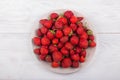 Strawberries on a plate on a white wooden background Royalty Free Stock Photo