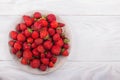 Strawberries on a plate on a white wooden background Royalty Free Stock Photo