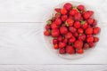 Strawberries on a plate on a white wooden background Royalty Free Stock Photo