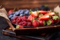 Strawberries, raspberries, blueberries, blackberries on a separate dish close-up on a solid concrete background. Healthy eating Royalty Free Stock Photo