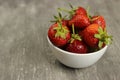 Strawberries ripe in a plate on a gray background
