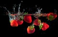 Strawberries splashing into water