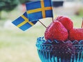 Strawberries with Swedish flags. Celebration of Swedens National Day or Midsummer.