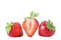 strawberries. Three strawberry fruits, one cut in half with flower on white background Royalty Free Stock Photo