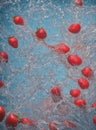 Strawberries in water splash on blue background.