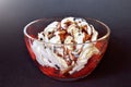 Strawberries with whipped cream and chocolate in a transparent bowl on a dark background with a white glow Royalty Free Stock Photo