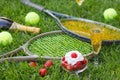 Strawberries with whipped cream, glass with champagne and tennis equipment on Wimbledon tournament grass