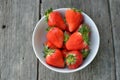 Strawberries in White bowl on wood background Royalty Free Stock Photo