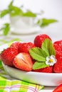 Strawberries in white porcelain bowl on a table. Bowl filled with juicy fresh ripe red strawberries. Royalty Free Stock Photo