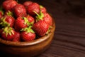 Strawberries in wooden bowl on brown table  closeup. Red ripe berries  fresh juicy strawberry on wooden background Royalty Free Stock Photo