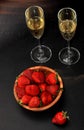 Strawberries in a wooden plate and two glasses of champagne on d Royalty Free Stock Photo