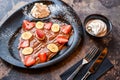 strawberry and banana Crepe with chocolate, whipped cream, knife and fork served in dish isolated on dark background closeup top Royalty Free Stock Photo