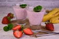 Strawberry-banana milkshake in glasses on a wooden background. Royalty Free Stock Photo