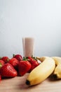 Strawberry banana smoothie fresh blended on wood table Royalty Free Stock Photo