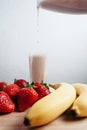 Strawberry banana smoothie fresh blended on wood table Royalty Free Stock Photo