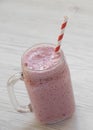 Strawberry banana smoothie in a glass jar mug over white wooden surface, low angle view. Close-up Royalty Free Stock Photo