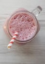 Strawberry banana smoothie in a glass jar mug over white wooden surface, top view. Close-up Royalty Free Stock Photo