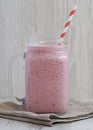 Strawberry banana smoothie in a glass jar over white wooden surface, side view. Close-up Royalty Free Stock Photo