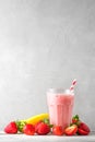 Strawberry and banana smoothie or milkshake in a glass with a straw with fresh fruits. refreshing summer drink Royalty Free Stock Photo