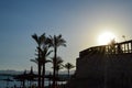 Strawberry beach sun-protective summer umbrellas made from hay, straw-shaped hats against the backdrop of the palm tops and copy t