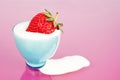 Strawberry in blue cup with yogurt spill