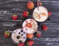 Strawberry, blueberry apricot organic fresh yogurt delicious oatmeal muesli on a black wooden background