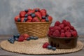 Strawberry and blueberry in basket and raspberries in bowl on wood table. Fresh berries. Royalty Free Stock Photo