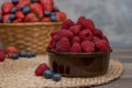 Strawberry and blueberry in basket and raspberries in bowl on wood table. Fresh berries Royalty Free Stock Photo