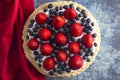 A Strawberry and Blueberry Fresh Summer Pie on a Distressed Blue Wooden Table