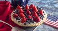 A Strawberry and Blueberry Fresh Summer Pie on a Distressed Blue Wooden Table