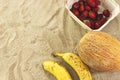 Strawberry box and melon, two bananas in sand Royalty Free Stock Photo