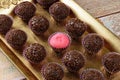 Strawberry Brigadeiro Bicho de pe surrounded by traditional brigadeiros brigadiers. Lined up on a golden tray