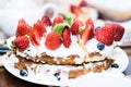 Strawberry cake in cream and mint leaves on the table in a plate