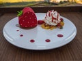 Strawberry cake and whipping cream on wooden table