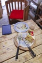 Strawberry cake on wooden table with knife, fork, tablet pc