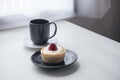 A strawberry cheese tart , a black cup of hot coffee and cactus on white vintage wooden table and curtain background Royalty Free Stock Photo