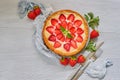 Strawberry cheesecake on the gray background with copy space. Decorated with many fresh strawberries, mint leaves, gray cloth