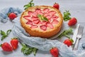 Strawberry cheesecake on the gray background decorated with many fresh strawberries, mint leaves, gray cloth, vintage silver knife Royalty Free Stock Photo