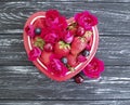 Strawberry, cherry, blueberry plate heart, fresh vintage appetizing flower rose on a black wooden background Royalty Free Stock Photo