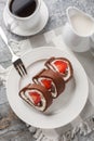 Strawberry chocolate Swiss roll cheesecake served with coffee close-up. Vertical top view Royalty Free Stock Photo