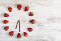 Strawberry clock with arrows from coffee beans, showing the time at six o`clock thirty minutes or eighteen hours thirty minutes on