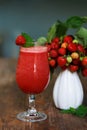 Strawberry cocktail in misted glass and white ceramic vase with ripe red strawberry branches Royalty Free Stock Photo