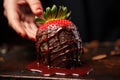 Strawberry covered with chocolate on a wooden table in a restaurant, A close-up of a hand-dipped chocolate covered strawberry, AI