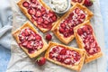 Strawberry, cream cheese and almond puff pastry pies on baking paper