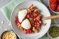 Strawberry crumble with ice cream and almonds in a plate with spoon on green napkin over gray background Royalty Free Stock Photo