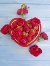 Strawberry dish heart, flower rose on colored wooden background