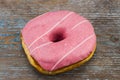 Strawberry donut with colorful sprinkles on wooden background Royalty Free Stock Photo