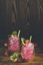 Strawberry drink with ice. Two glass of strawberry ice drink with ripe berry on wooden turquoise table surface. Alcoholic