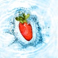 Strawberry dropped into blue water Royalty Free Stock Photo