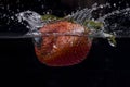 Strawberry dropped into water with a splash. Royalty Free Stock Photo